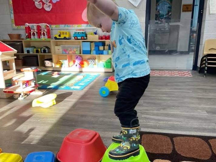 child stepping on colored blocks